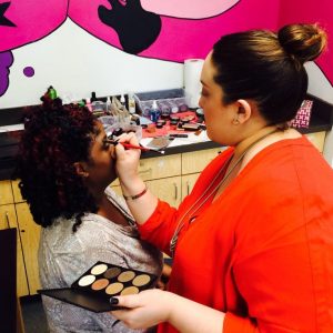 A makeup artist helps a job seeker get ready for the Hiring Event!